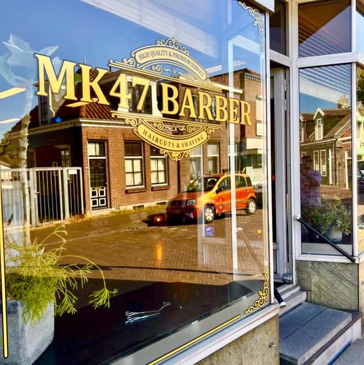 Het raam van MK47 Barber met de gouden letters, gezien vanaf de Zuiddijk