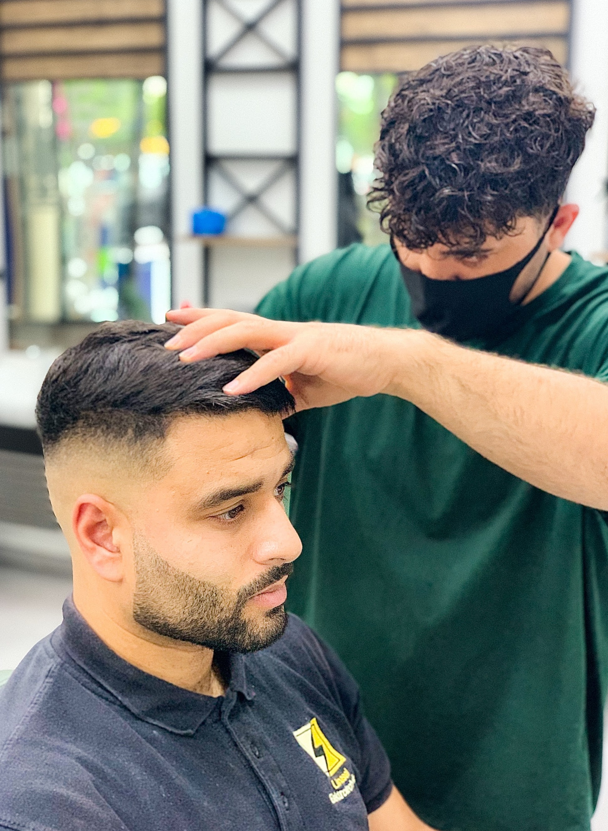Barbier stylet het haar van een klant na een fade