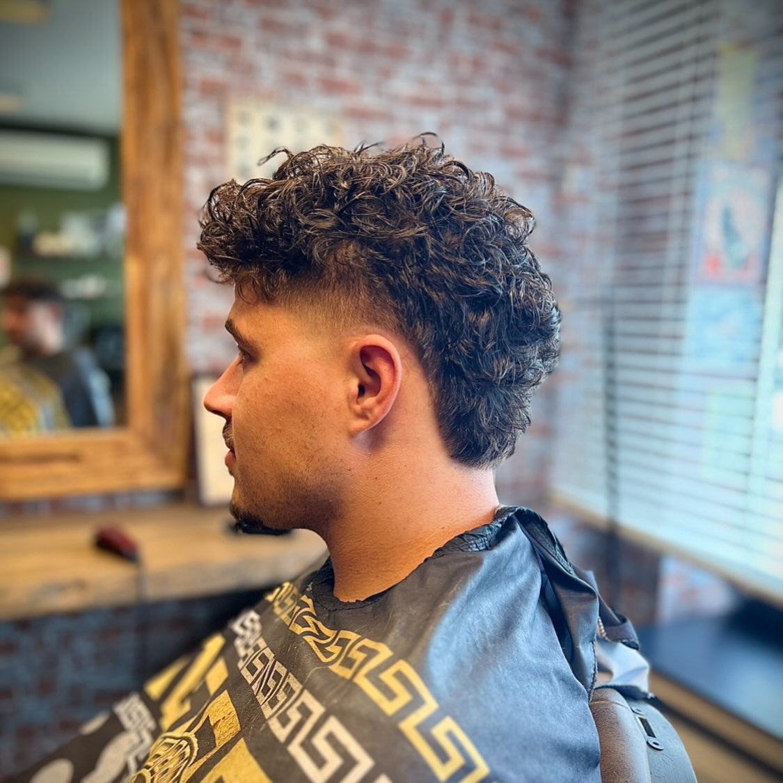 Krullend haar met een fade aan de zijkant, van opzij
